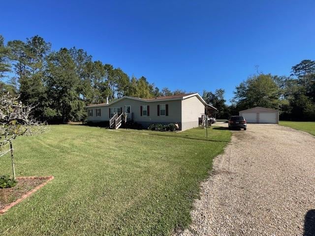 view of front of home featuring a garage, a front yard, and an outbuilding