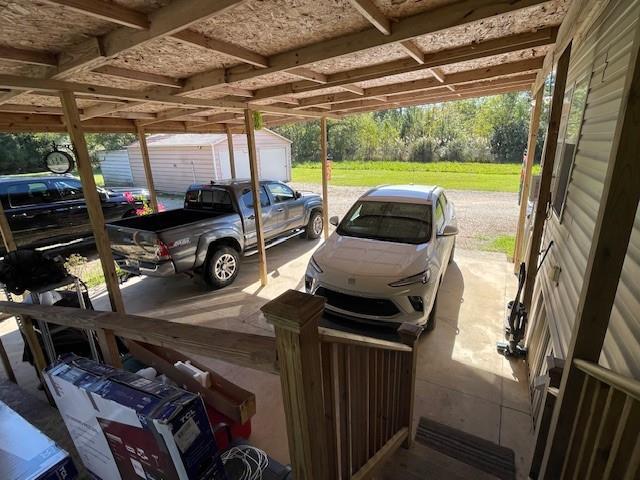 view of vehicle parking featuring a storage unit