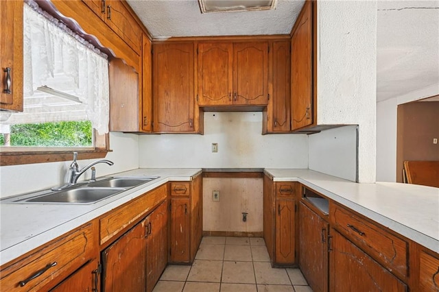 kitchen featuring sink, light tile patterned floors, and a textured ceiling