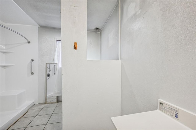 bathroom with a textured ceiling and tile patterned floors