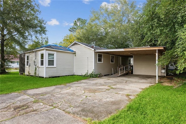 back of property featuring a carport and a yard