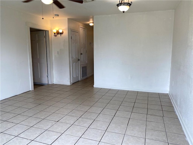 tiled spare room featuring ceiling fan