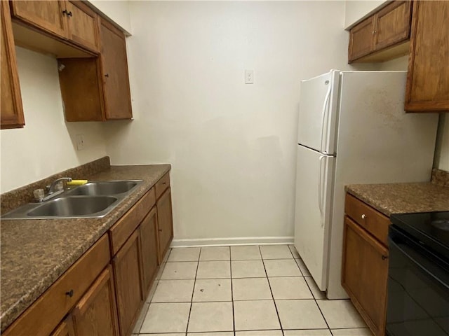 kitchen with light tile patterned flooring, white refrigerator, black / electric stove, and sink