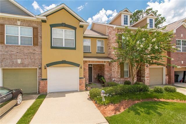 townhome / multi-family property featuring a garage and a front lawn