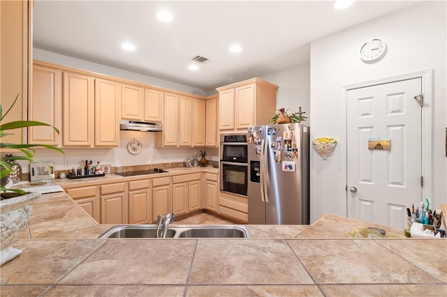 kitchen with kitchen peninsula, sink, light tile patterned floors, and stainless steel appliances