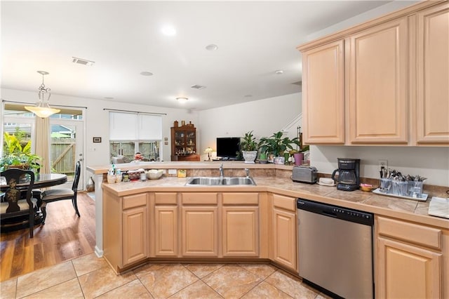 kitchen with kitchen peninsula, a kitchen breakfast bar, light hardwood / wood-style flooring, and appliances with stainless steel finishes