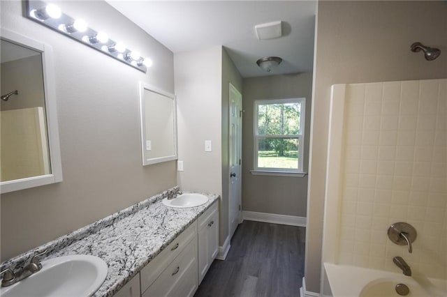 bathroom with vanity, tiled shower / bath, and hardwood / wood-style flooring