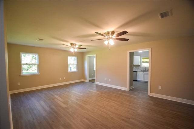 spare room with dark hardwood / wood-style flooring, ceiling fan, and sink