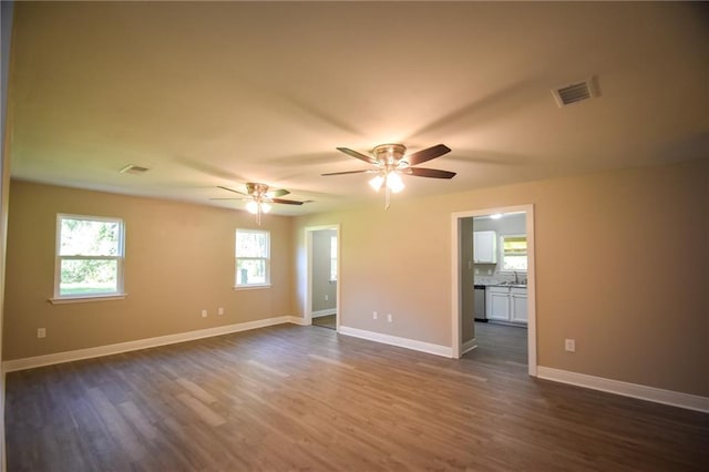 spare room with ceiling fan, sink, and dark hardwood / wood-style floors