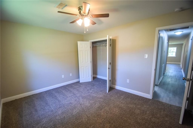 unfurnished bedroom featuring ceiling fan, a closet, and dark carpet