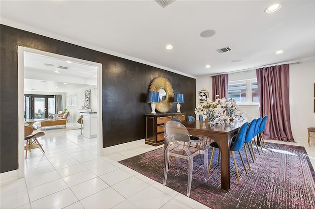 tiled dining area featuring crown molding