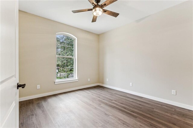 empty room with ceiling fan and wood-type flooring