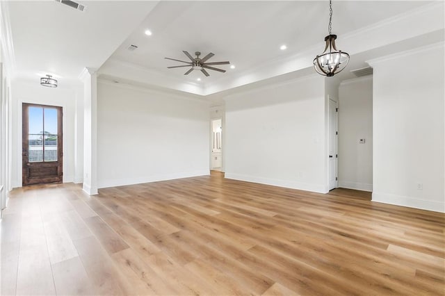 unfurnished living room featuring crown molding, a tray ceiling, light hardwood / wood-style floors, and ceiling fan with notable chandelier