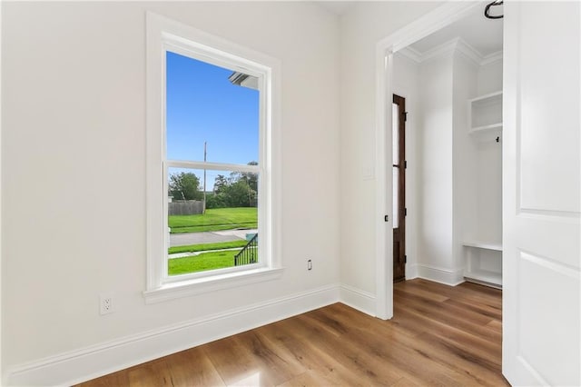 empty room featuring crown molding and hardwood / wood-style floors