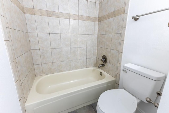 bathroom featuring toilet and tiled shower / bath