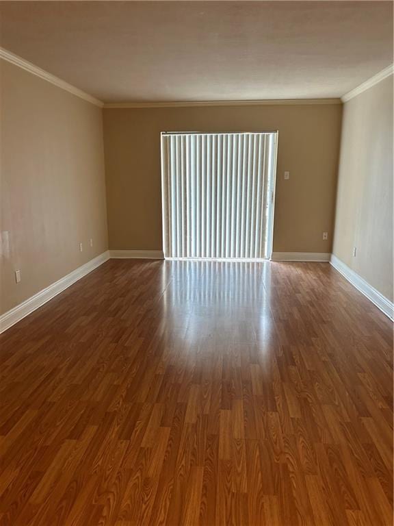 empty room with hardwood / wood-style floors and ornamental molding