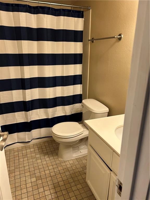 bathroom with tile patterned floors, vanity, toilet, and a shower with shower curtain