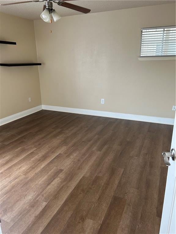 empty room featuring ceiling fan, dark hardwood / wood-style flooring, and a textured ceiling