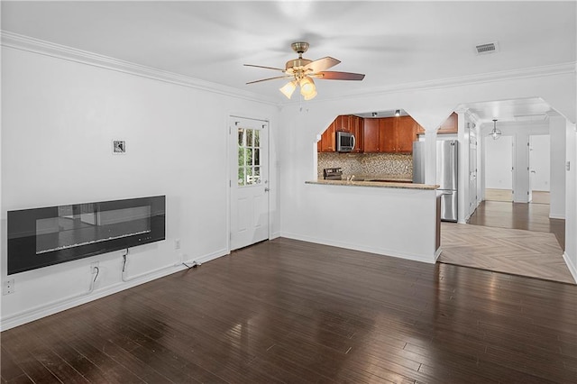 unfurnished living room featuring heating unit, crown molding, ceiling fan, and dark hardwood / wood-style floors