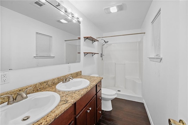 bathroom featuring vanity, toilet, wood-type flooring, and a shower