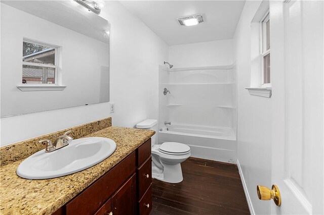 full bathroom with hardwood / wood-style floors, vanity, toilet, and shower / bathing tub combination