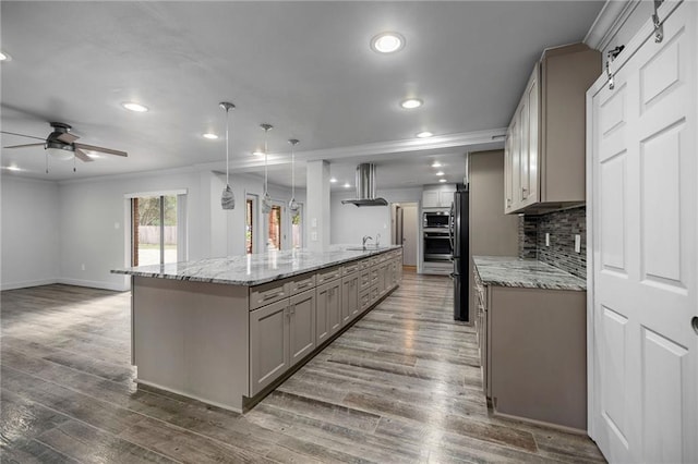 kitchen with dark hardwood / wood-style flooring, a center island, hanging light fixtures, and range hood