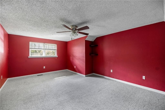 spare room featuring a textured ceiling, carpet floors, vaulted ceiling, and ceiling fan