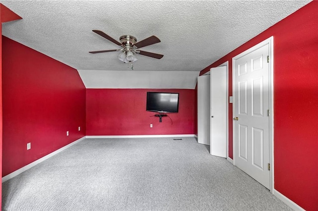 unfurnished living room featuring ceiling fan, lofted ceiling, and a textured ceiling