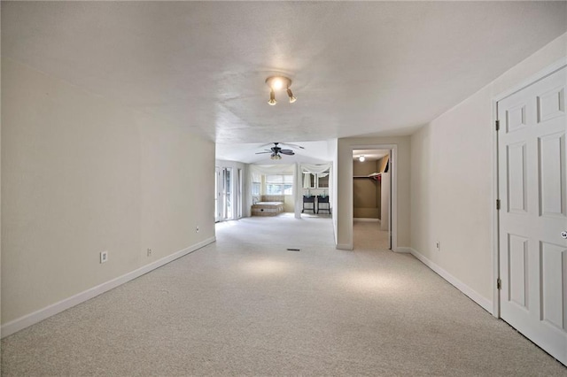 unfurnished living room featuring ceiling fan and light colored carpet