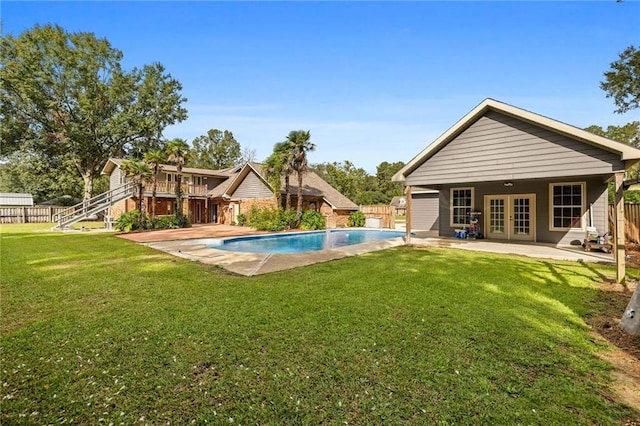 view of pool with a yard, a patio area, and french doors