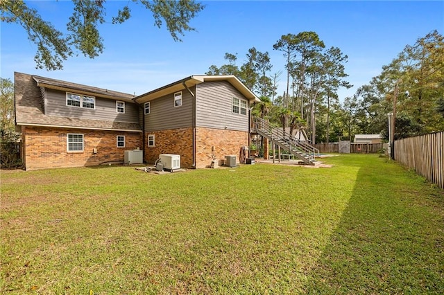 rear view of house with a yard and central AC