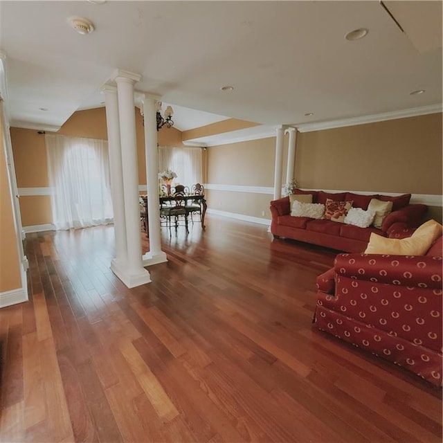 living room with hardwood / wood-style flooring, ornate columns, and crown molding