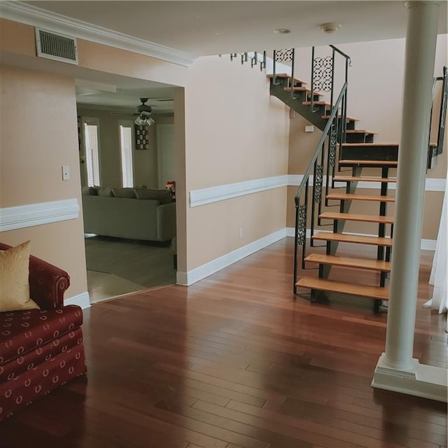 staircase featuring hardwood / wood-style floors, ceiling fan, ornate columns, and crown molding