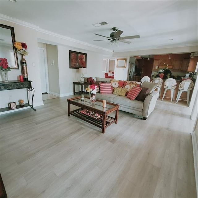 living room featuring light wood-type flooring, ceiling fan, and ornamental molding