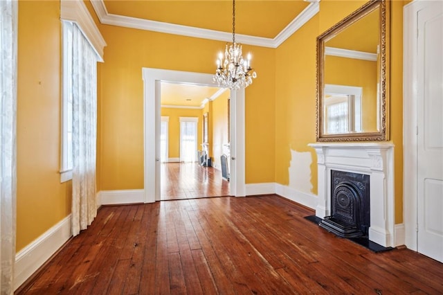 unfurnished living room with hardwood / wood-style floors, a notable chandelier, and crown molding