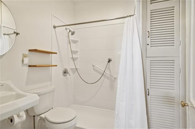 bathroom with a shower with shower curtain, toilet, and sink