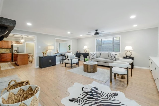 living room with ceiling fan, light hardwood / wood-style floors, and ornamental molding