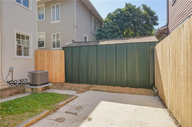 view of yard with central AC, an outbuilding, and a patio