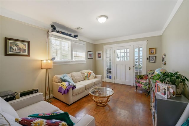 living room featuring wood-type flooring, crown molding, and a healthy amount of sunlight