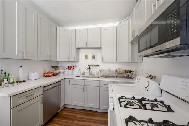 kitchen with dark hardwood / wood-style flooring, sink, and stainless steel appliances