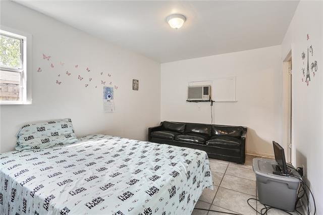 bedroom featuring a wall unit AC and light tile patterned floors