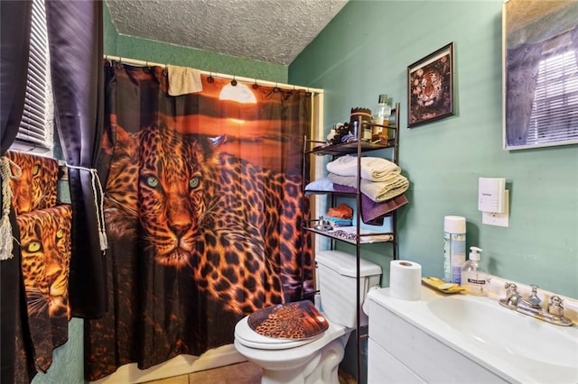 bathroom with tile patterned flooring, vanity, a textured ceiling, and toilet