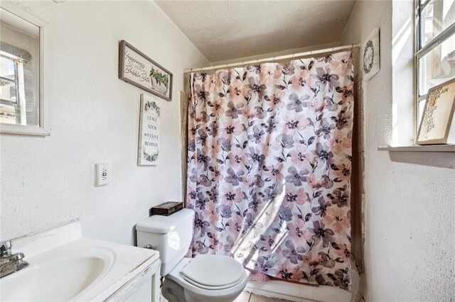 full bathroom with vanity, shower / tub combo, a textured ceiling, and toilet