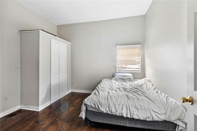 bedroom with a closet and dark wood-type flooring