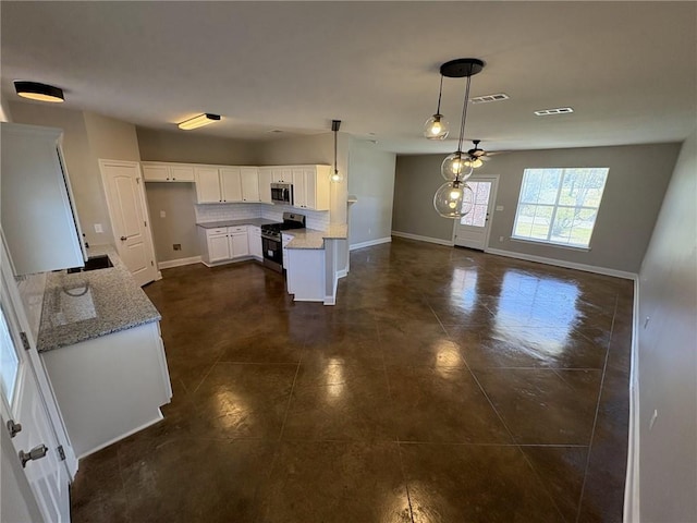 kitchen featuring ceiling fan, hanging light fixtures, light stone counters, white cabinets, and appliances with stainless steel finishes