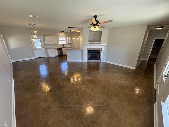 unfurnished living room with ceiling fan and sink