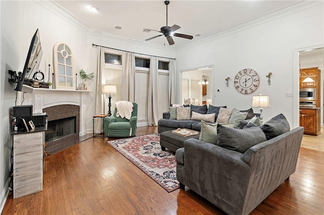 living room featuring crown molding, ceiling fan, and wood-type flooring