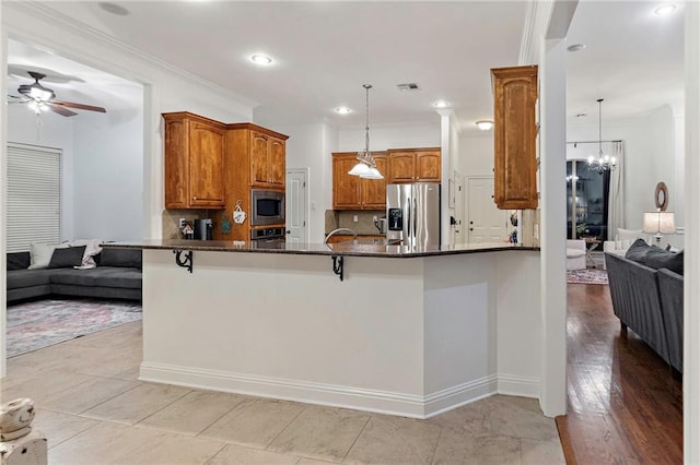 kitchen featuring kitchen peninsula, pendant lighting, and stainless steel appliances