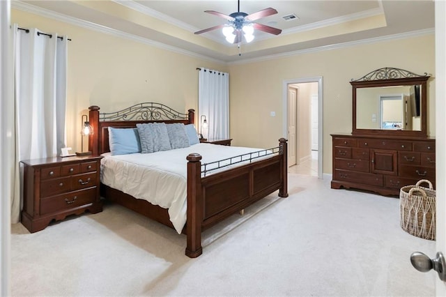 carpeted bedroom with ceiling fan, ornamental molding, and a tray ceiling