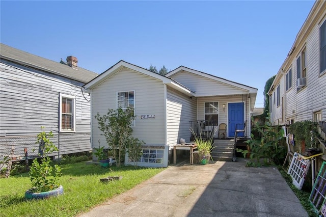 1311 Frenchmen St, New Orleans, LA 70116 - view of front of house with covered porch, a front yard, and cooling unit